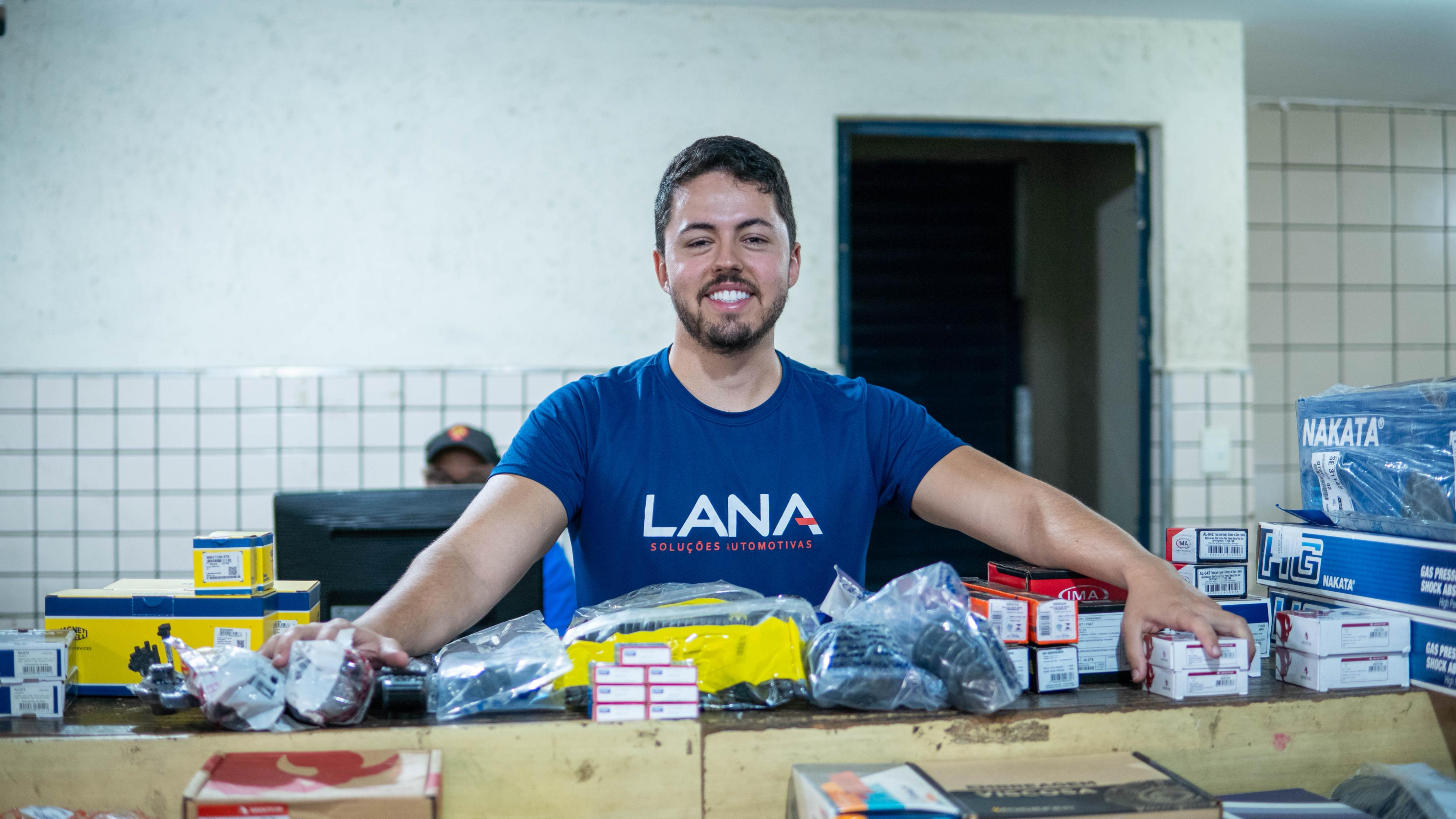 Funcionário da Lana Soluções Automotivas com peças no depósito